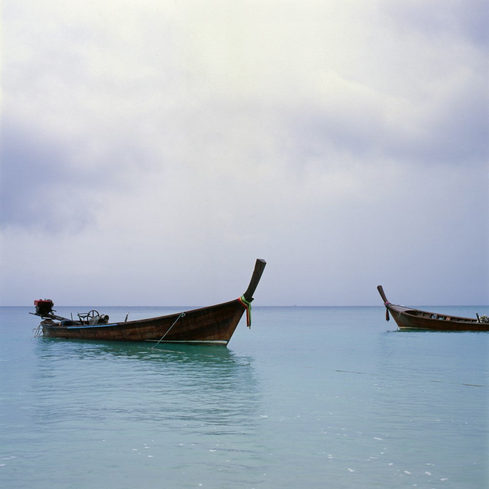 two brown motorboat on body of water