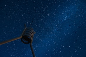 A surreal landscape where robotic arms reach towards a starry sky filled with data streams.