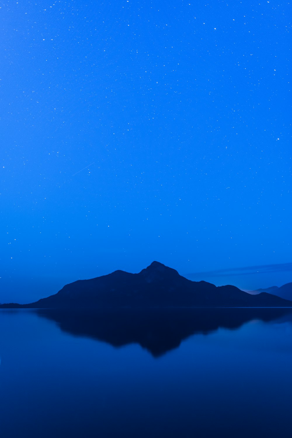 silhouette photo of mountains beside sea