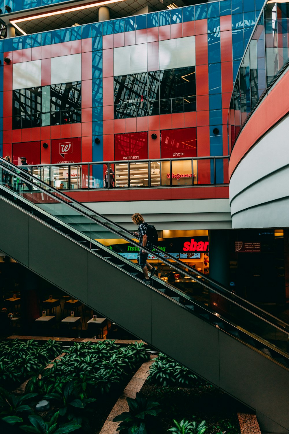 person carrying backpack on escalator photo