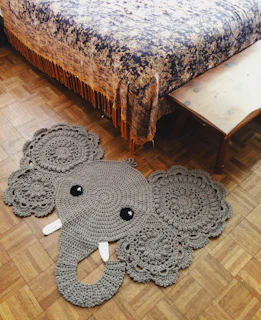 black and gray elephant plush toy on brown wooden table