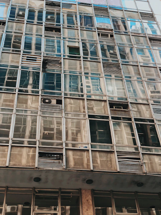 Close-up of a clear silicone sealant being applied to a glass facade joint.