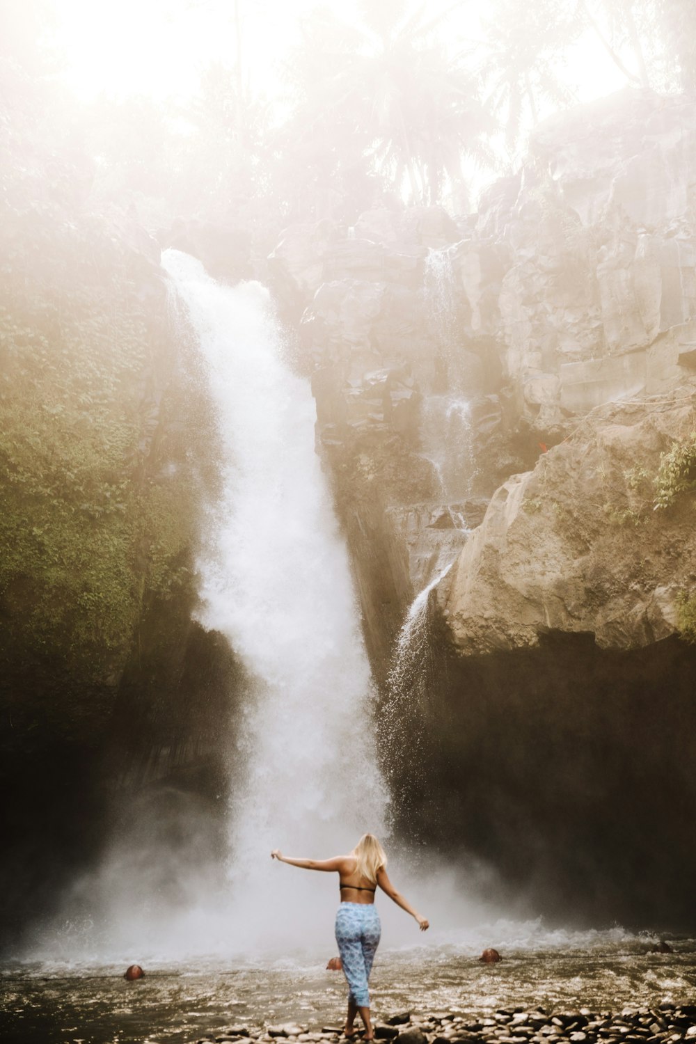 woman standing in front of plunge waterfall