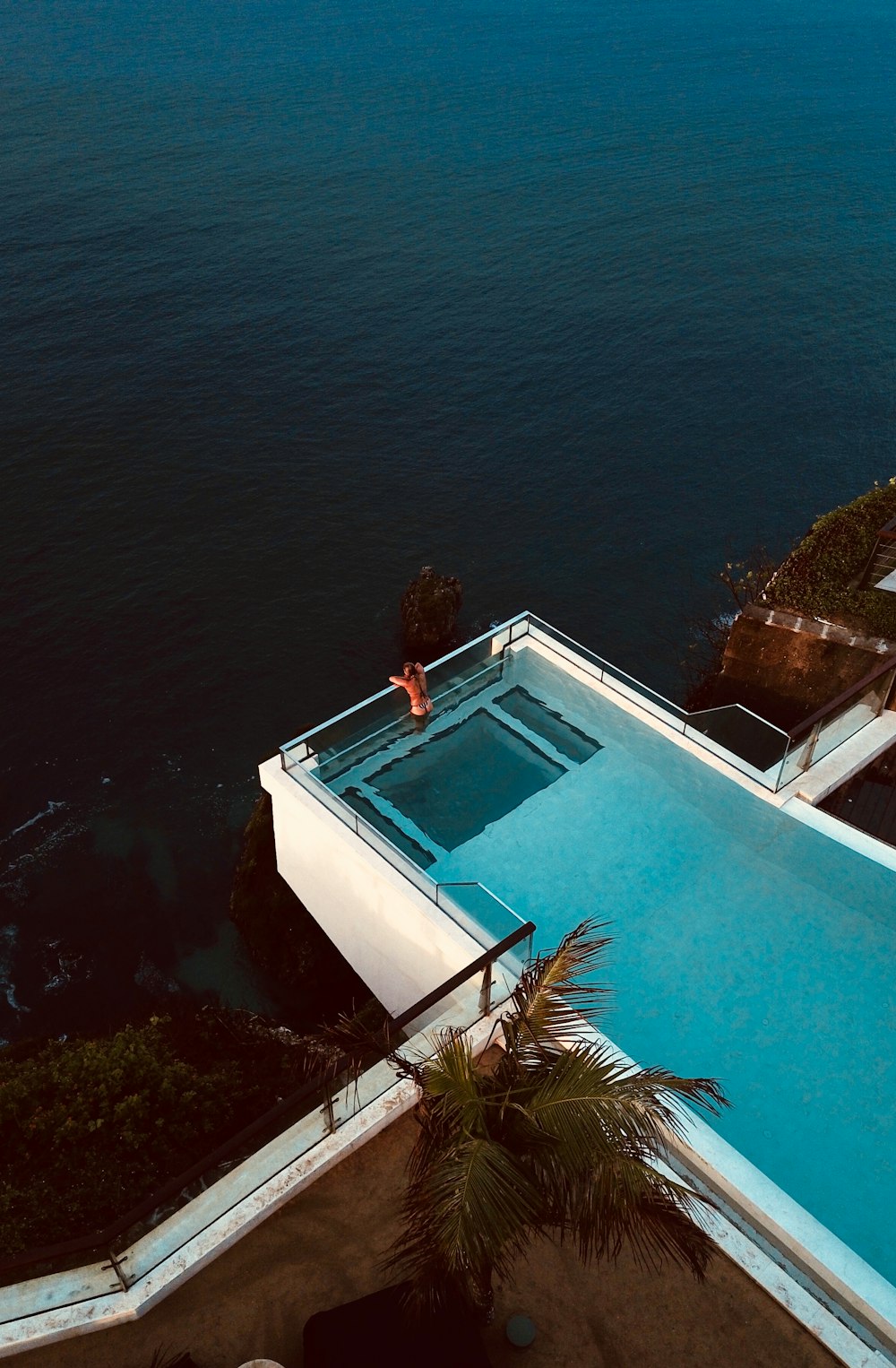 person floating on pool while looking in the sea