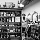 grayscale photography of barber shaving another man's chin