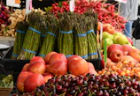 Close-up of fresh farm produce artfully arranged on a market stall with deep crimson accents.