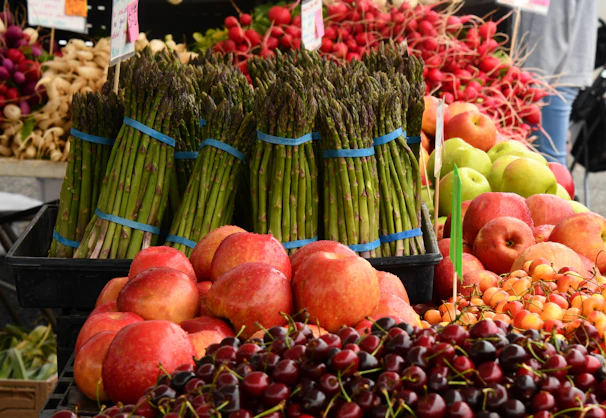 Close-up of vibrant, fresh produce arranged artfully on a market stall, highlighting deep reds and greens.
