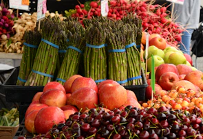 Close-up of fresh farm produce artfully arranged on a market stall with deep crimson accents.