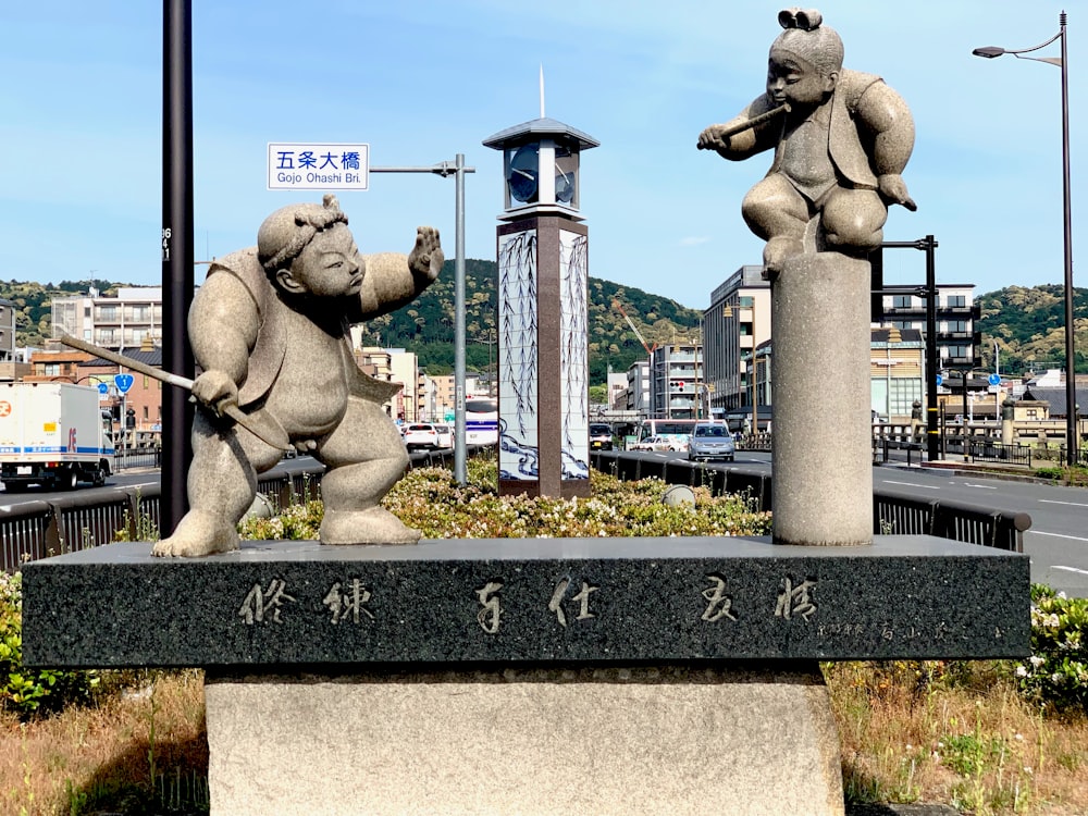 two grey men fighting ceramic statues
