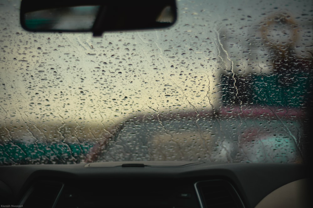 a view of a car through a rain covered windshield