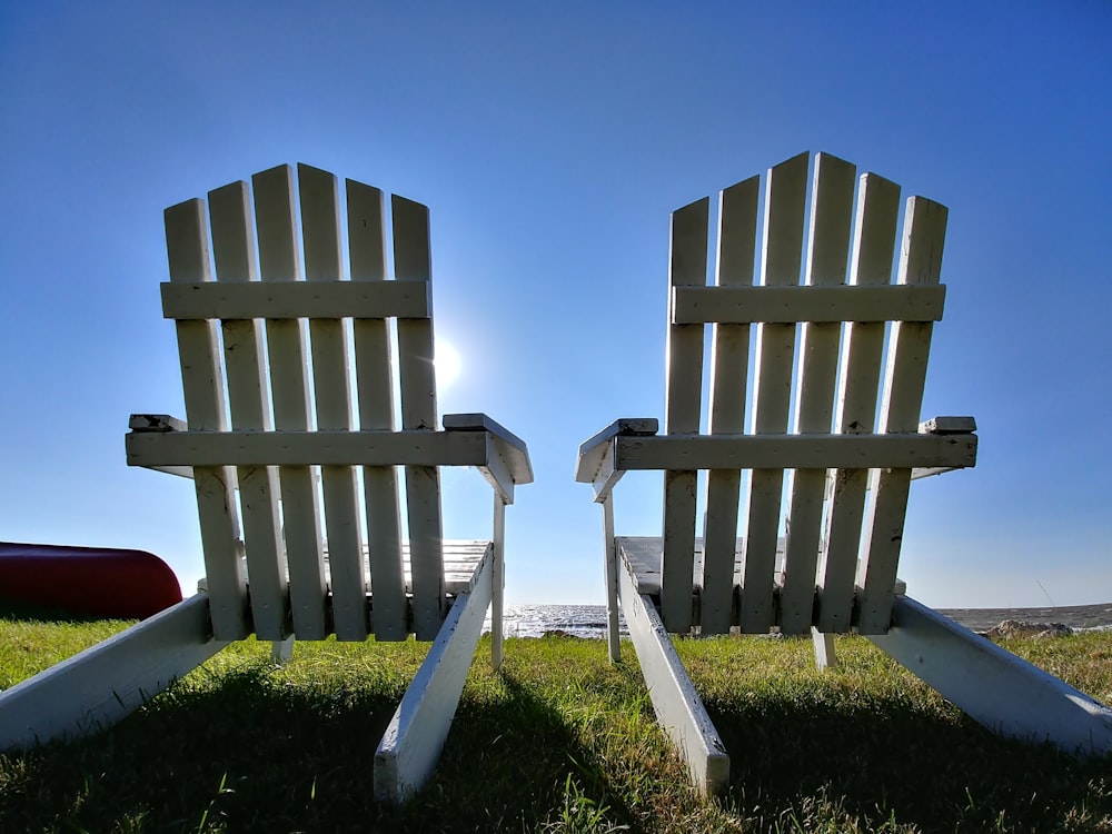 two white wooden adirondack chairs