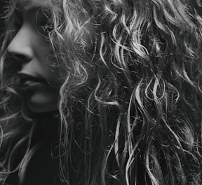 a black and white photo of a woman with curly hair