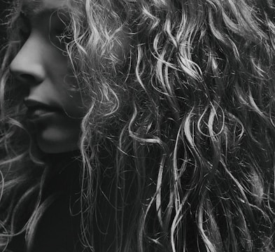 a black and white photo of a woman with curly hair