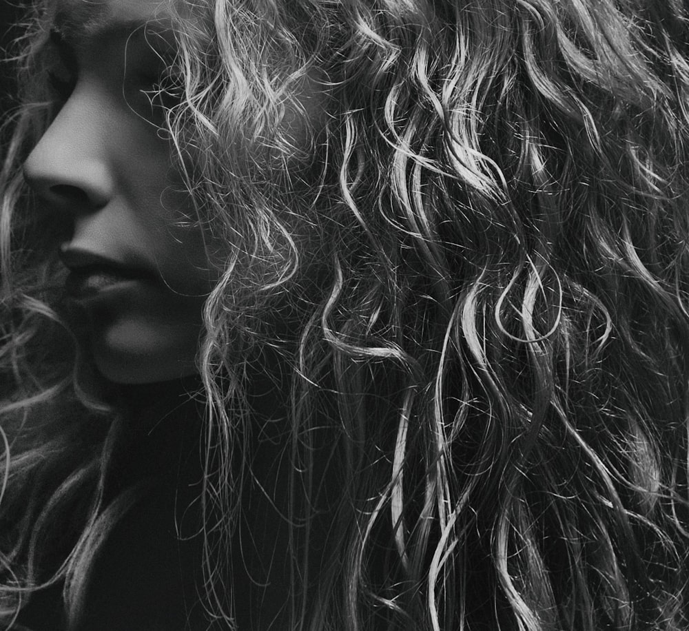 a black and white photo of a woman with curly hair