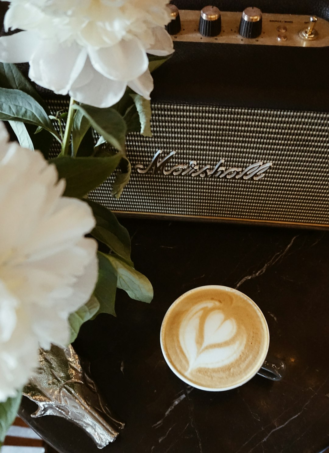 white ceramic coffee cup besides black Marshall guitar amplifier