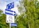 blue and white signage near trees during daytime