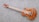 A wooden electric guitar with a natural finish rests on a textured gray carpet. It features a glossy body with intricate wood grain patterns and metallic hardware components such as pickups and control knobs. The guitar neck contains distinct red fret markings.