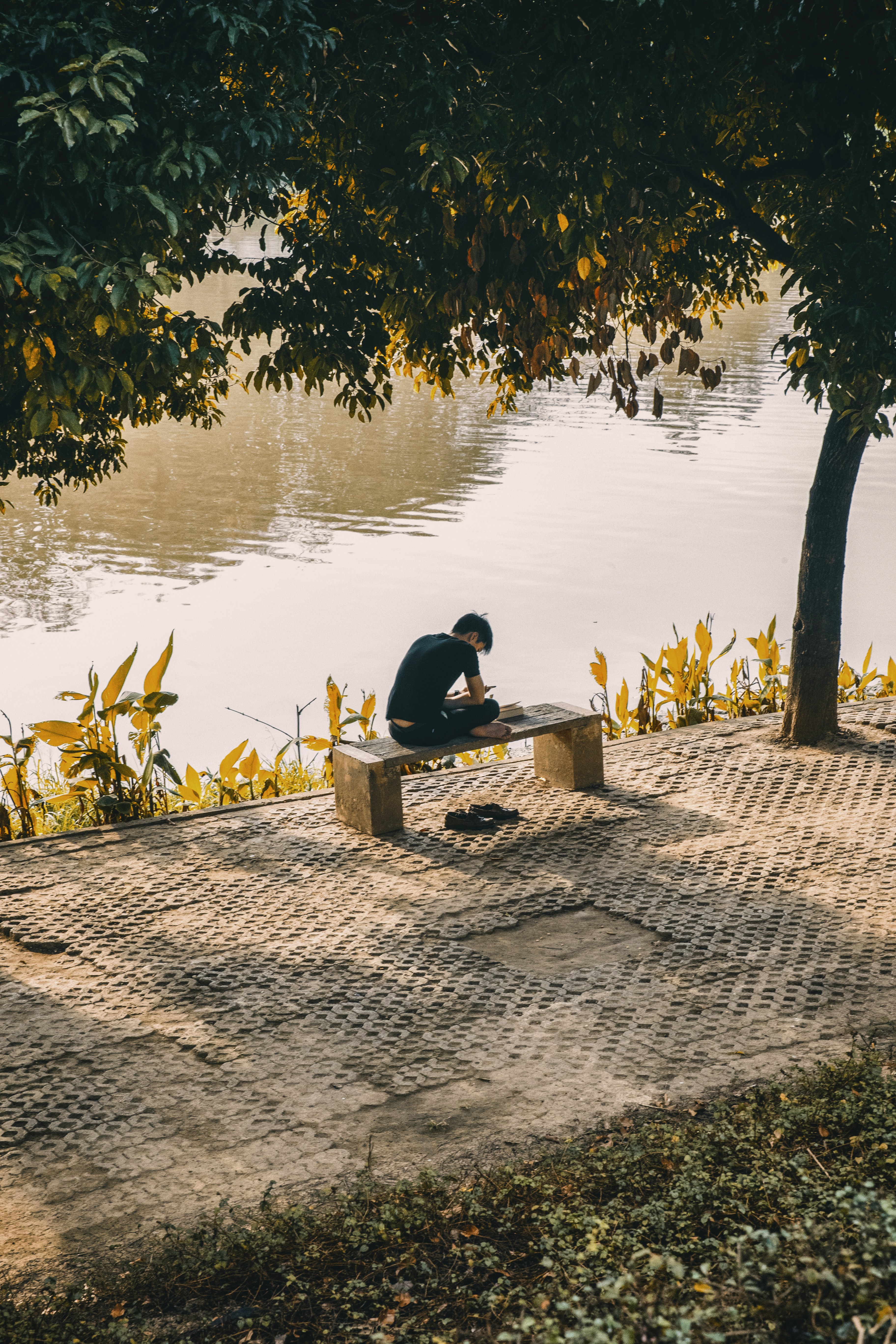 Man reading by the river in Chiang Mai
