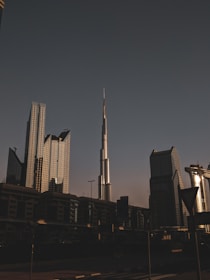 a tall building towering over a city next to other tall buildings