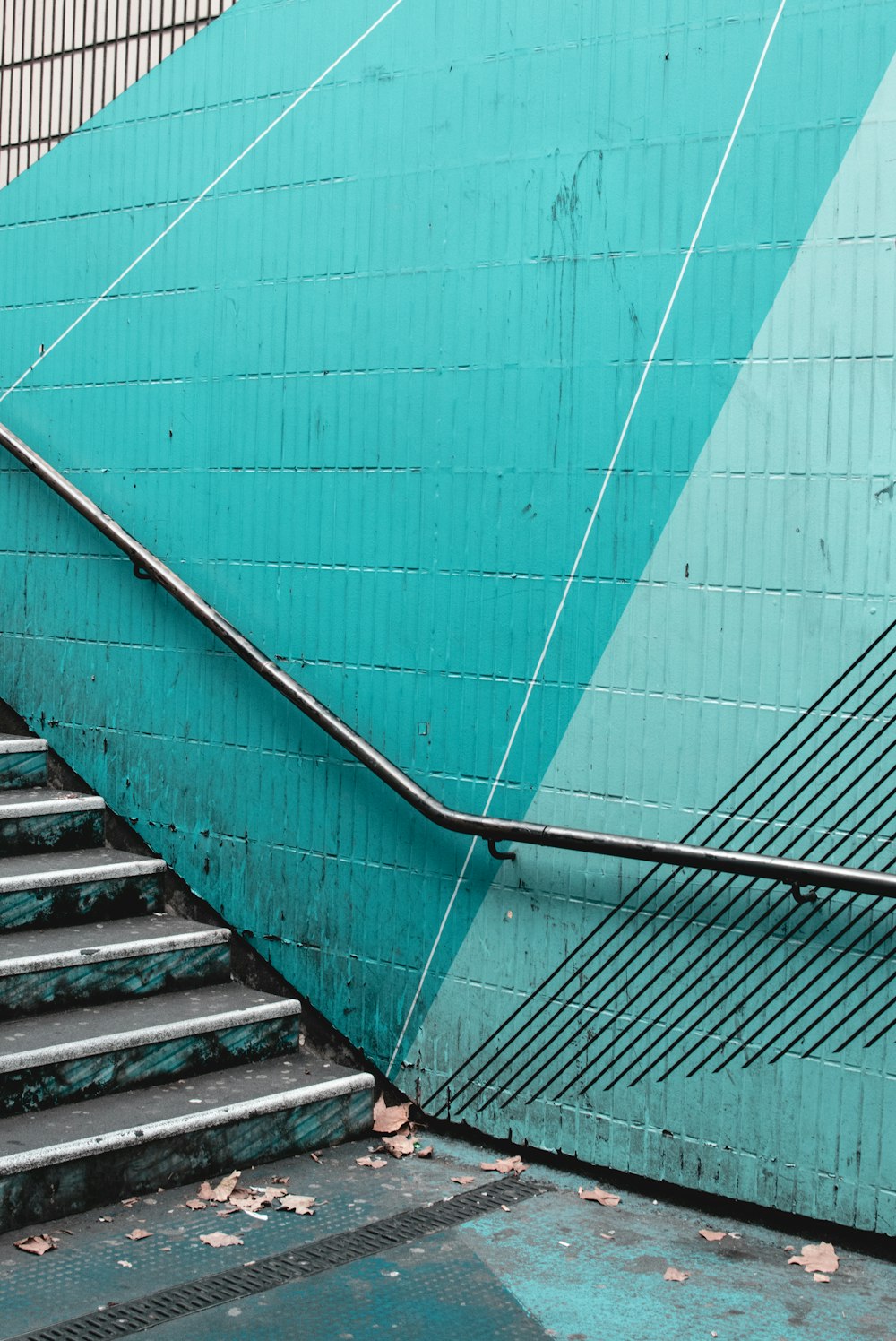 a man walking down a flight of stairs next to a blue wall