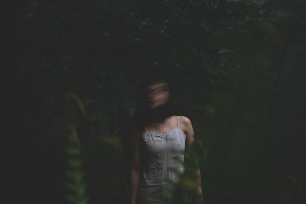 standing woman near fern plants