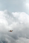 Close-up aerial shot of a drone in flight against a dramatic cloudy sky backdrop.