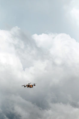 Close-up aerial shot of a drone in flight against a dramatic cloudy sky backdrop.