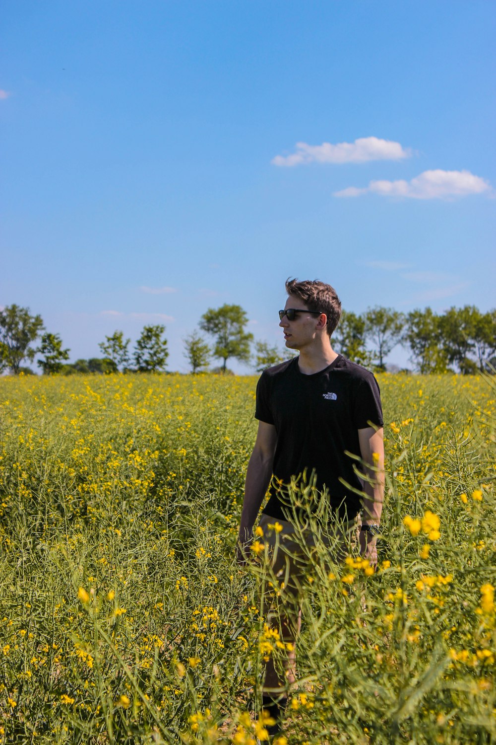 man wearing black t-shirt surrounded by flower