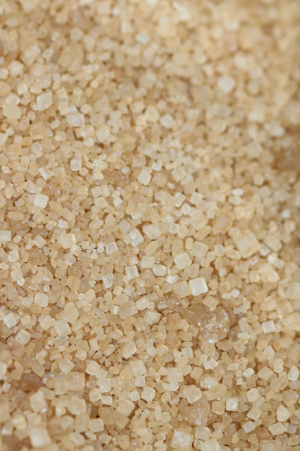 Close-up of premium brown sugar crystals being processed in a modern facility.