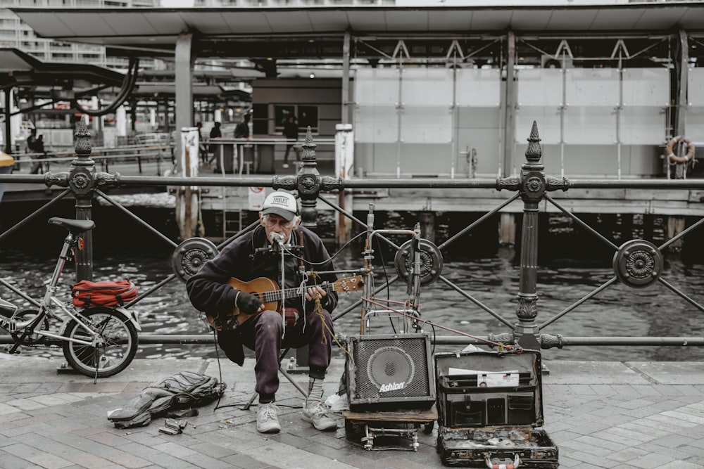 man playing guitar on street