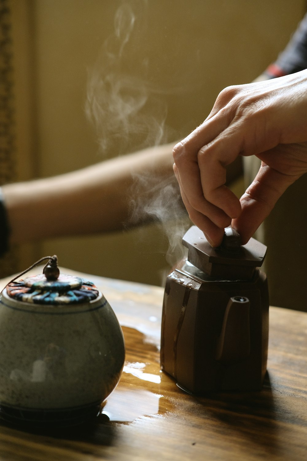 person taking lid of jar emitting smoke