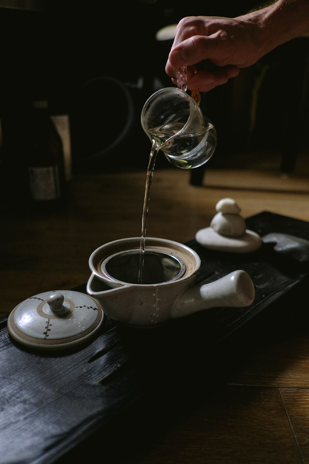person pouring water on teapot