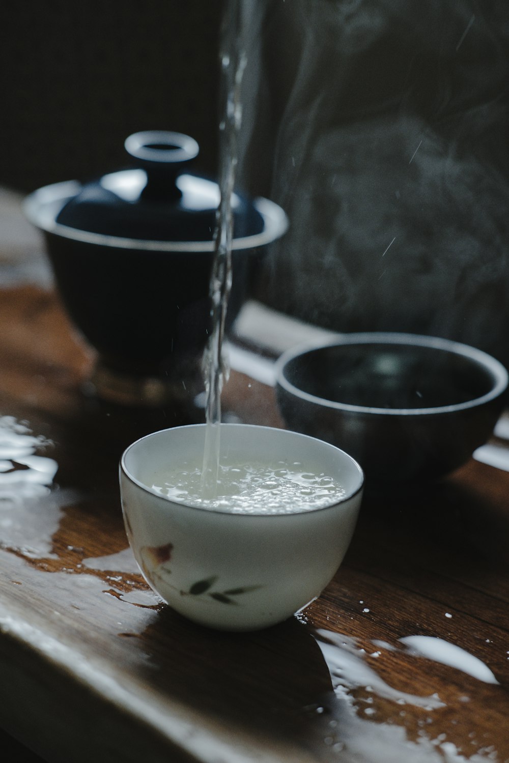 liquid pouring on white bowl near black bowl