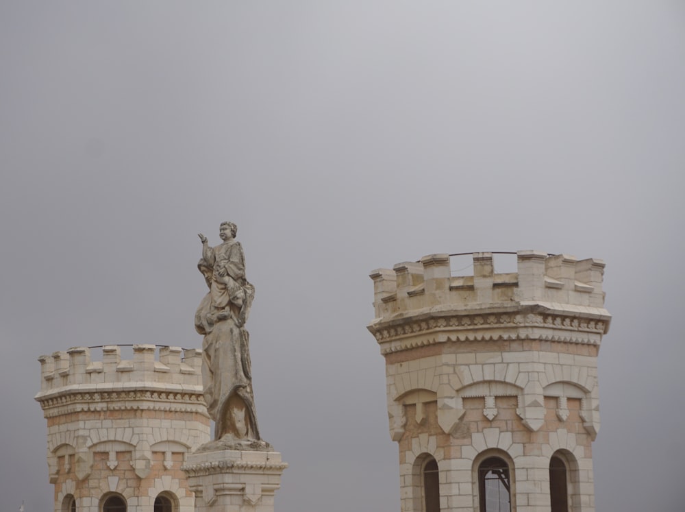 low-angle photography of building with statue on tower during daytime