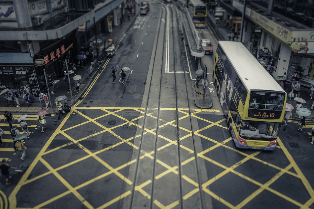 yellow and white double decker bus on road