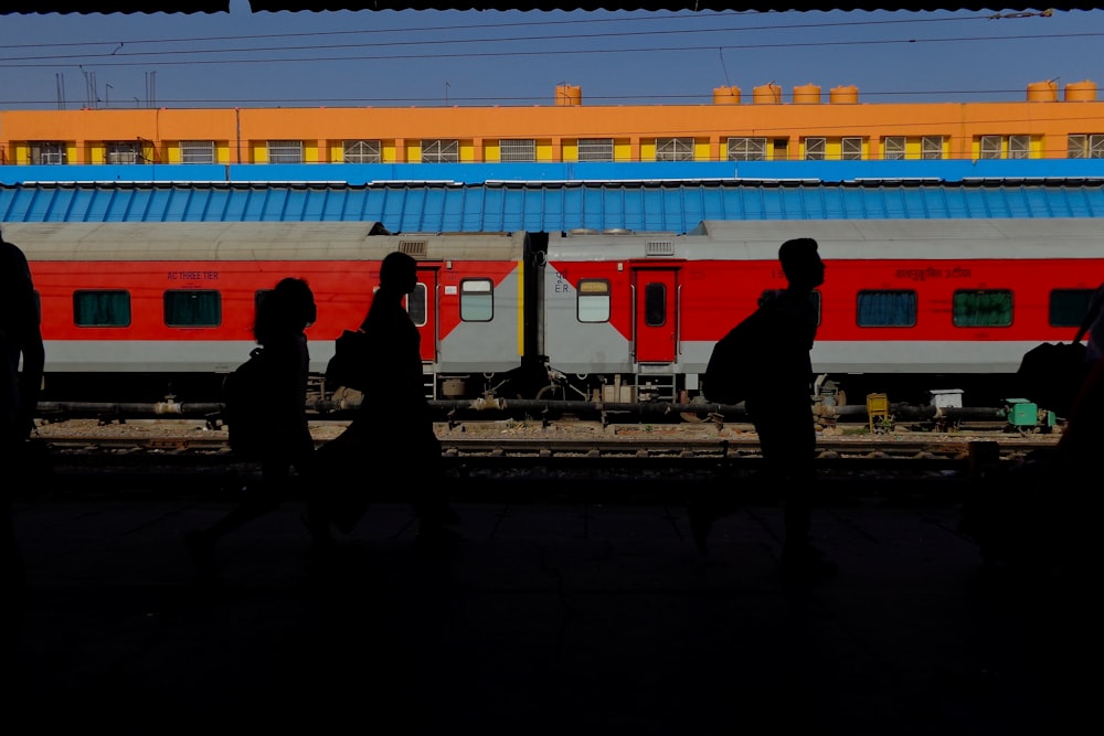 silhouette of people walking by train during daytime