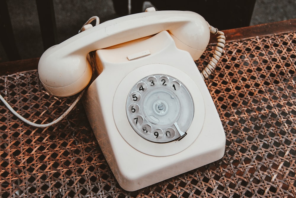 white and beige rotary telephone