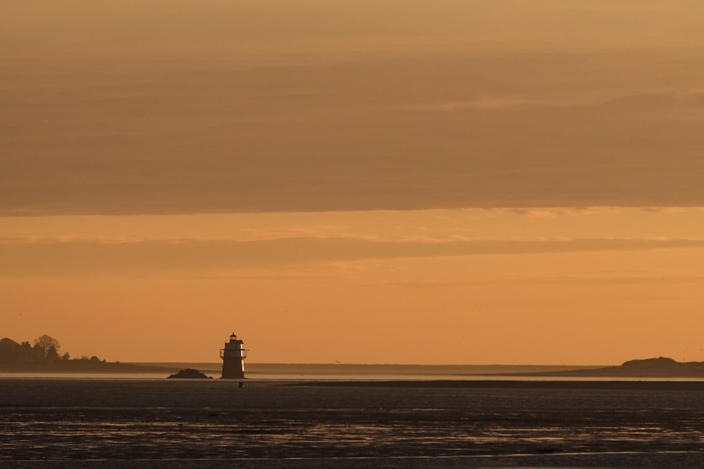 lighthouse near beach during dusk