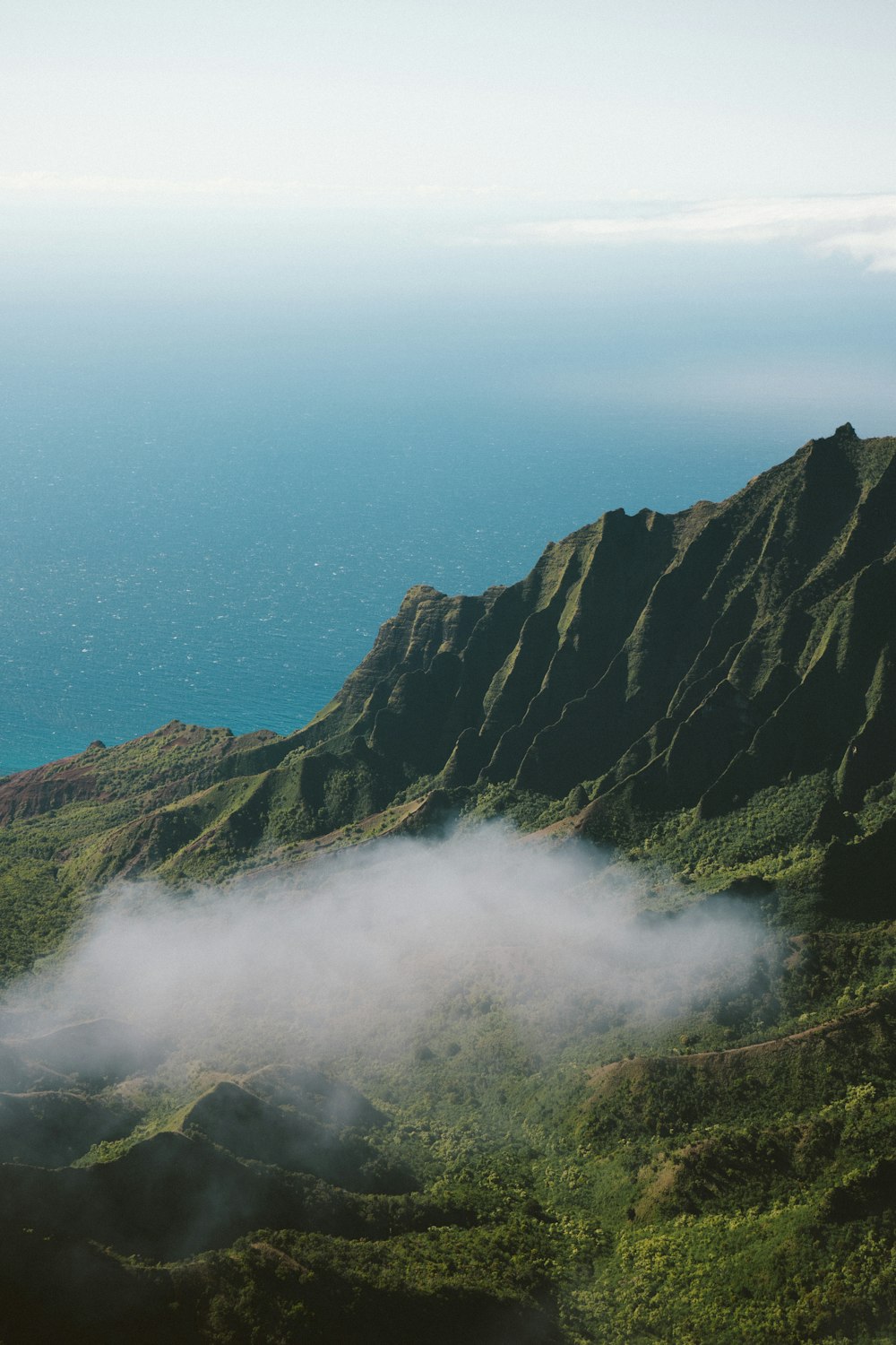 Una vista de una montaña con una nube en el aire