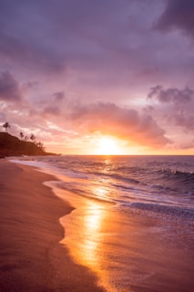 Waikiki Beach with Diamond Head volcanic crater in the background and palm trees lining the white sand shore