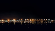 Evening scene of the airport with lights glowing warmly as planes prepare for departure.