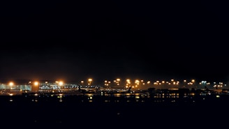 Evening scene of the airport with lights glowing warmly as planes prepare for departure.