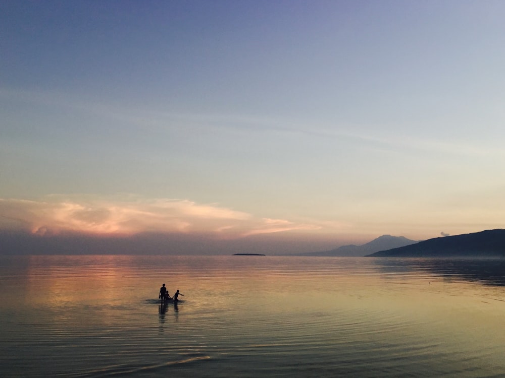 person on body of water during golden hour