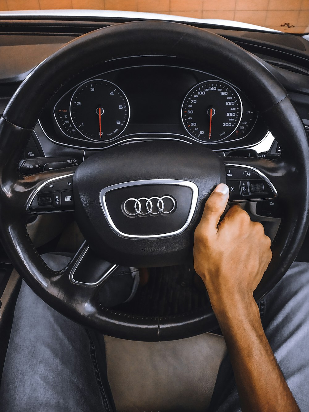 person holding Audi steering wheel
