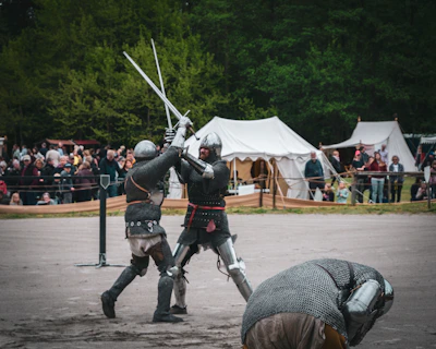 Armored knights demonstrating sword fighting techniques during the reenactment.