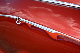 A shiny red car after a fresh paint job in a professional body shop.