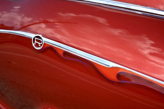 A close-up of a car being detailed with a shiny finish and protective film applied.