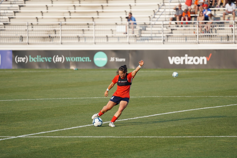 mujer pateando pelota de fútbol