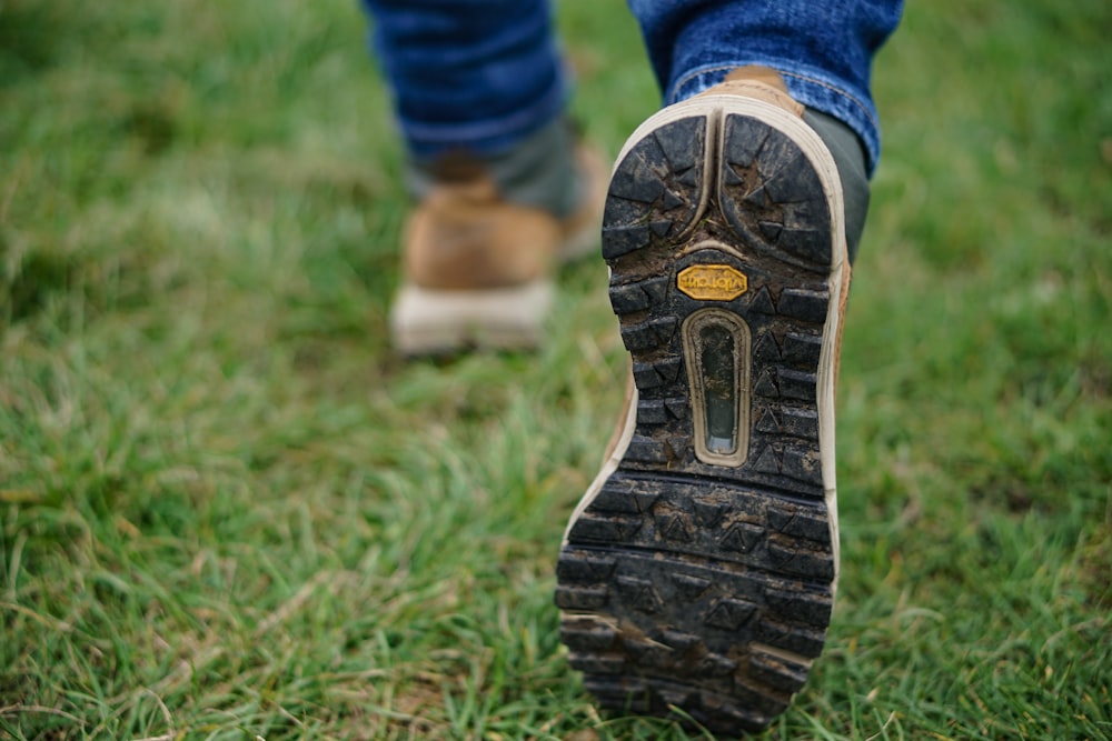 persona che indossa scarpe marroni e nere