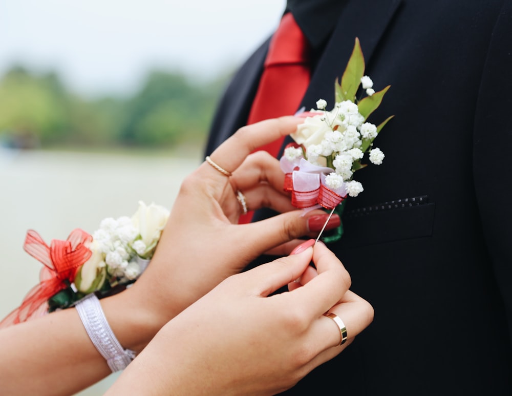 woman putting white flower on man's suit